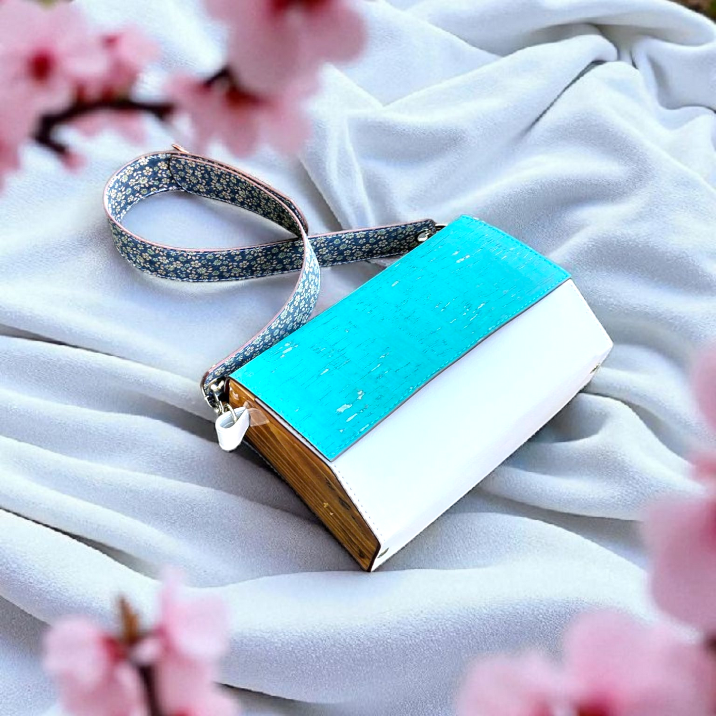 Blue and white handbag with floral pattern on a white fabric background