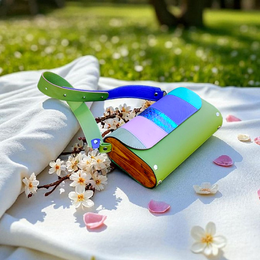 Colorful book-shaped object on a white blanket with flowers in an outdoor setting