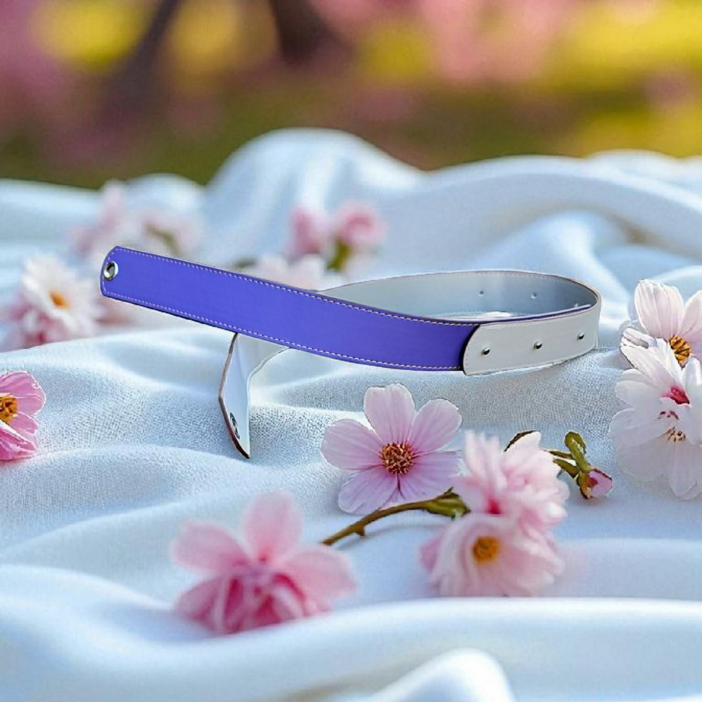 Purple and silver belt on a white fabric with pink flowers and blurred floral background
